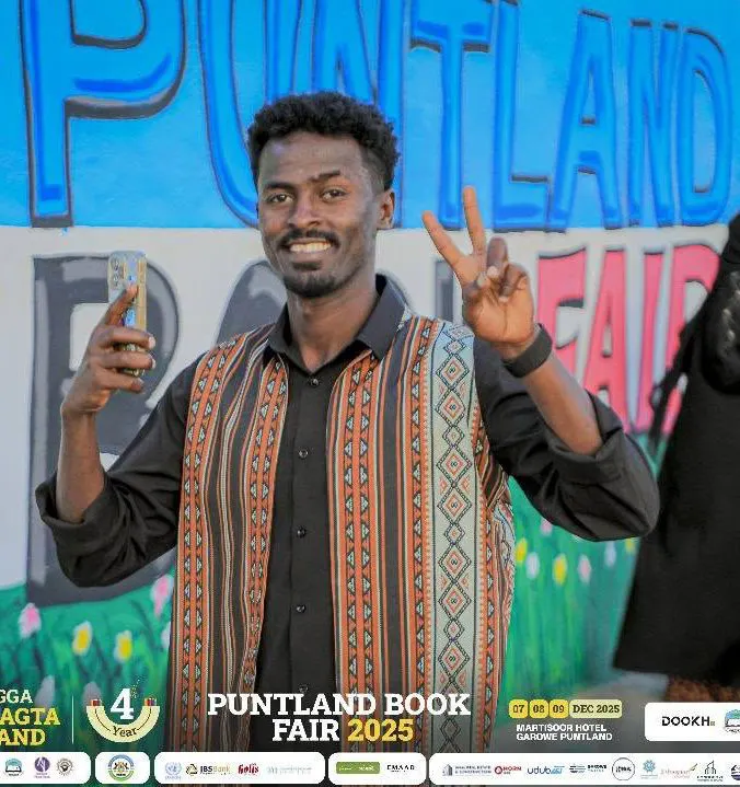 Participant in front of the Puntland Book Fair mural